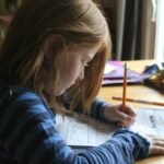 girl learning abc with a tracing sheets