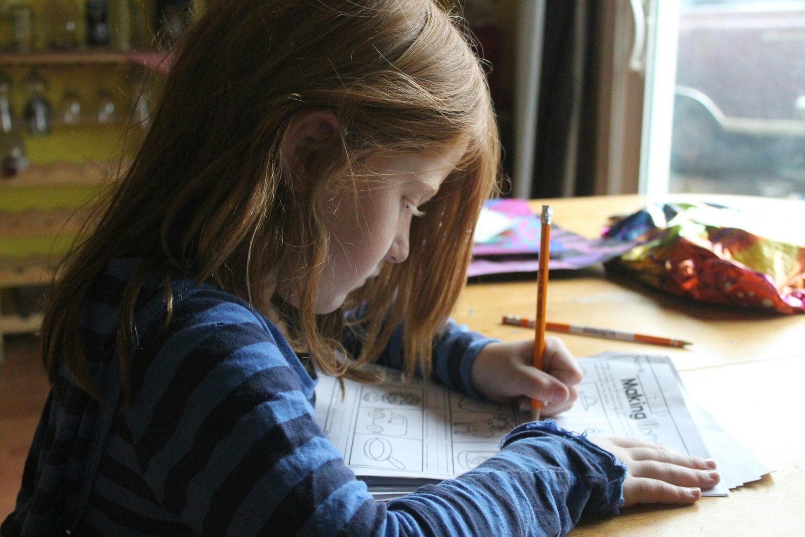 girl learning abc with a tracing sheets